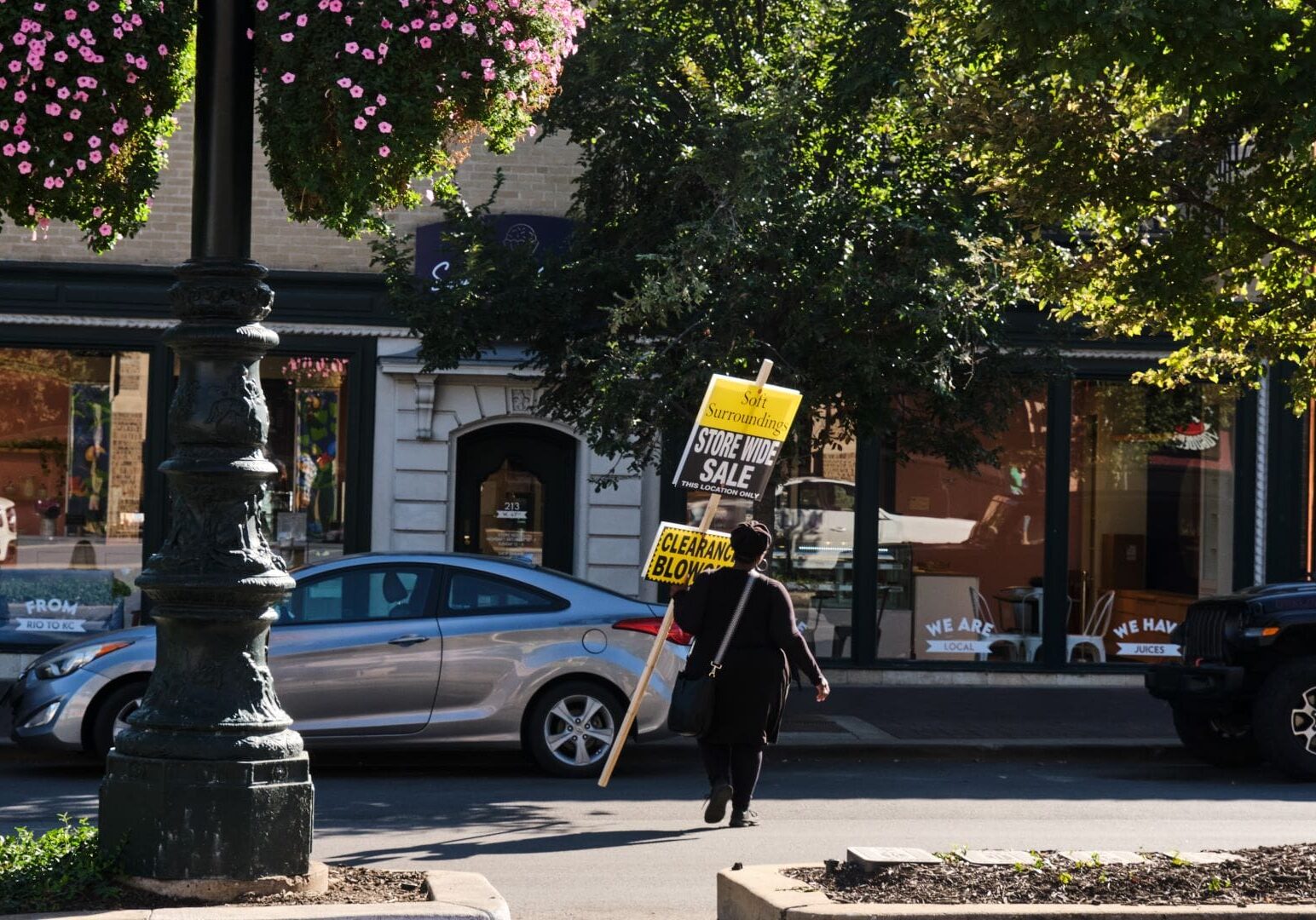 A worker carries a clearance sale sign on the Country Club Plaza.