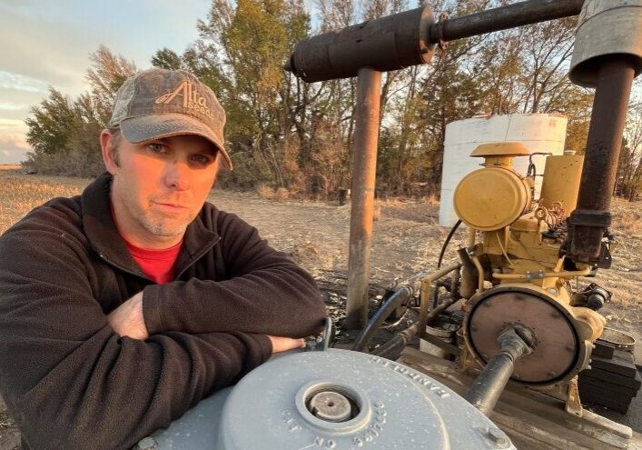 Haskell County farmer Travis Leonard stands next to his well that finally gave out this year. It's one of several that have run out of water on his farm in southwest Kansas in recent years as the Ogallala aquifer declines.