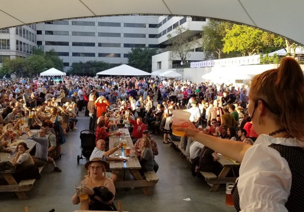 KC Oktoberfest crowd hoists a beer In celebration.