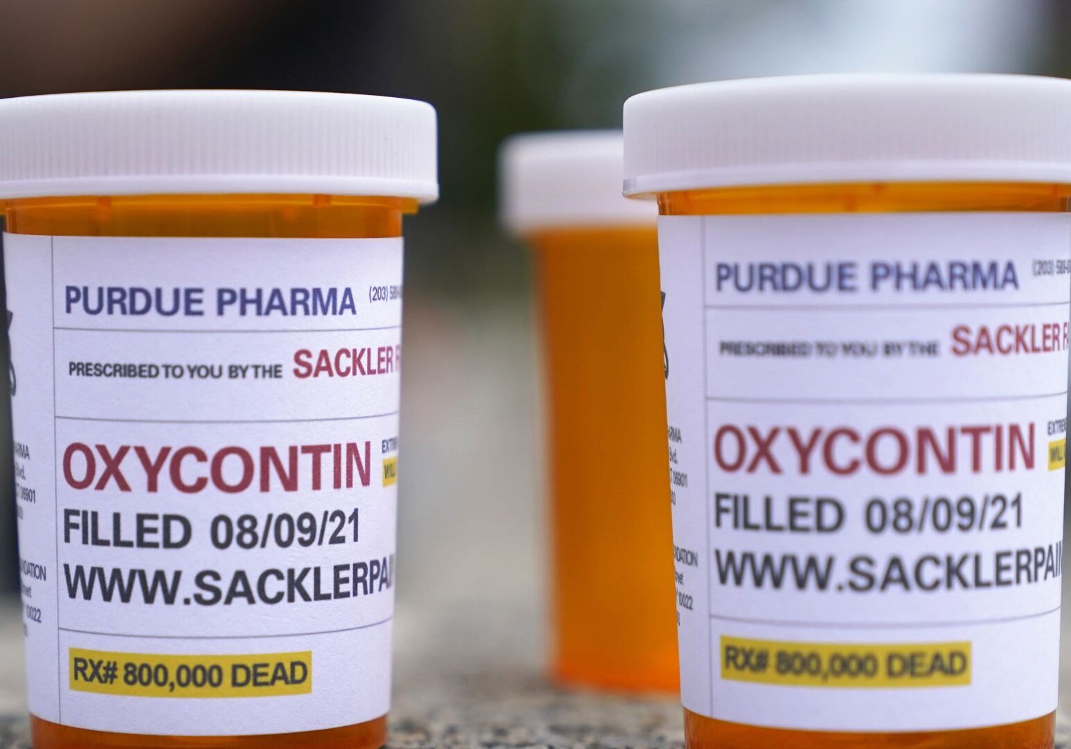 Fake pill bottles with messages about OxyContin maker Purdue Pharma are displayed during a protest outside the courthouse where the bankruptcy of the company was taking place in White Plains, New York.