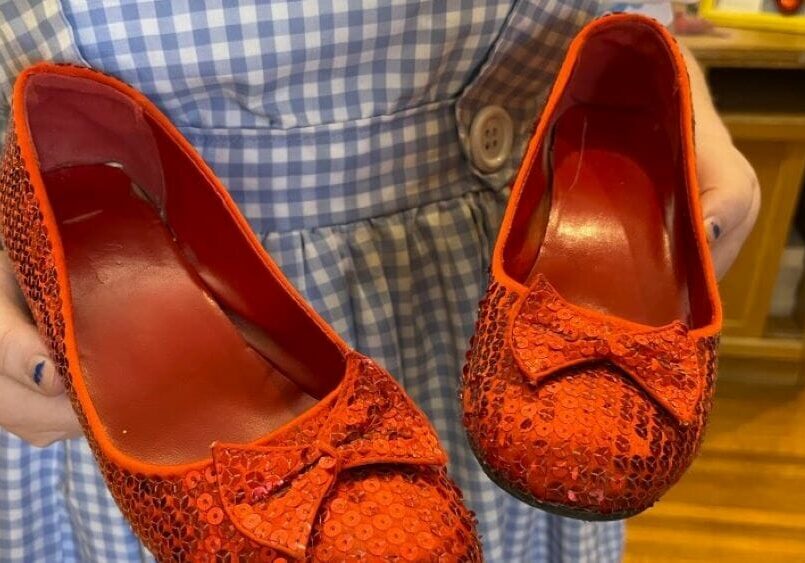 A Dorothy Gale impersonator who works at Dorothy's House in Liberal, Kansas, holds a pair of ruby slippers she wears while leading tours of the museum.