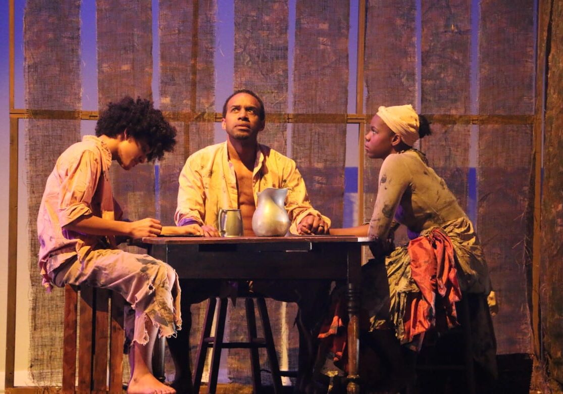 Three individuals on stage.