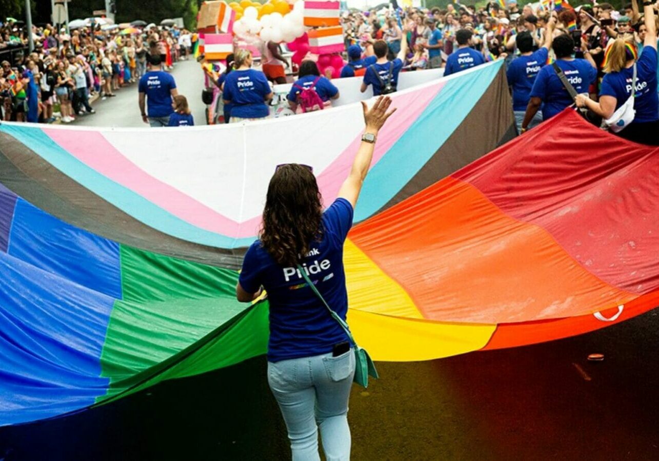 Marchers carry a huge flag during Kansas City's Pride Parade 2023.