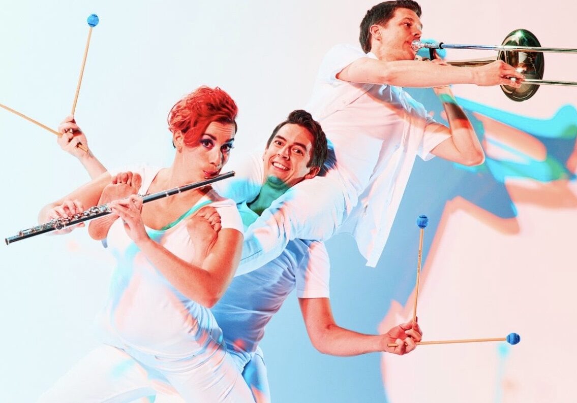 Three performers pose with instruments.