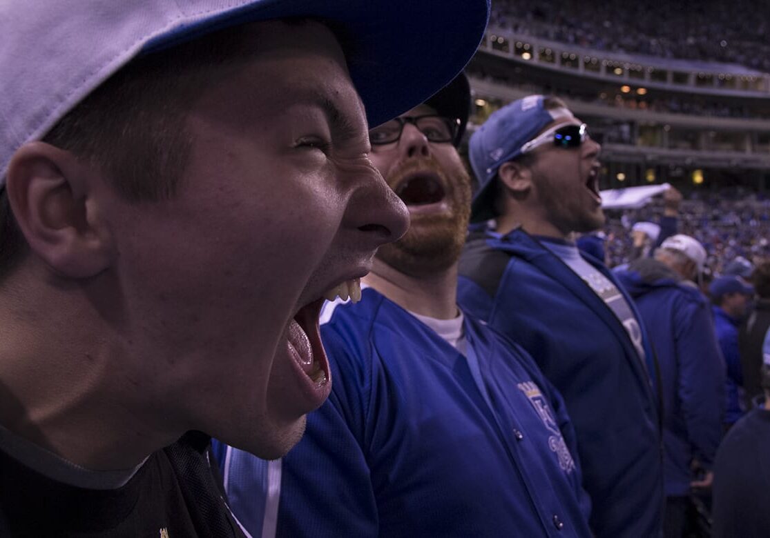 Photo of Royals fans at a game shouting and celebrating.