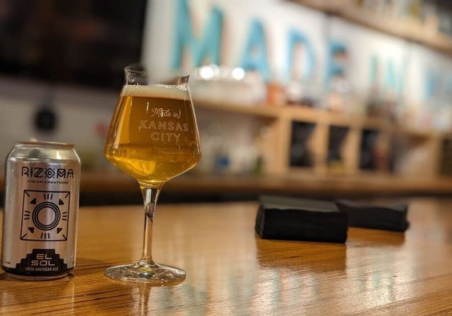 Rizoma beer in a glass and can on a bar.