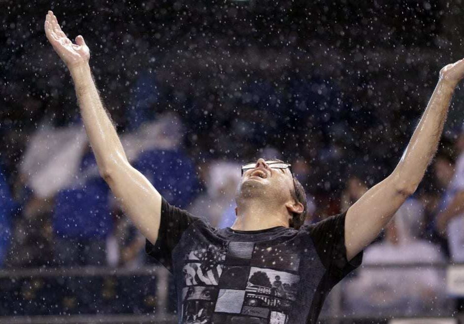 A fan waits out a rain delay in Game 6 of baseball's American League Championship Series between the Kansas City Royals and the Toronto Blue Jays on Friday, Oct. 23, 2015, in Kansas City. (Photo: Charlie Riedel | AP)