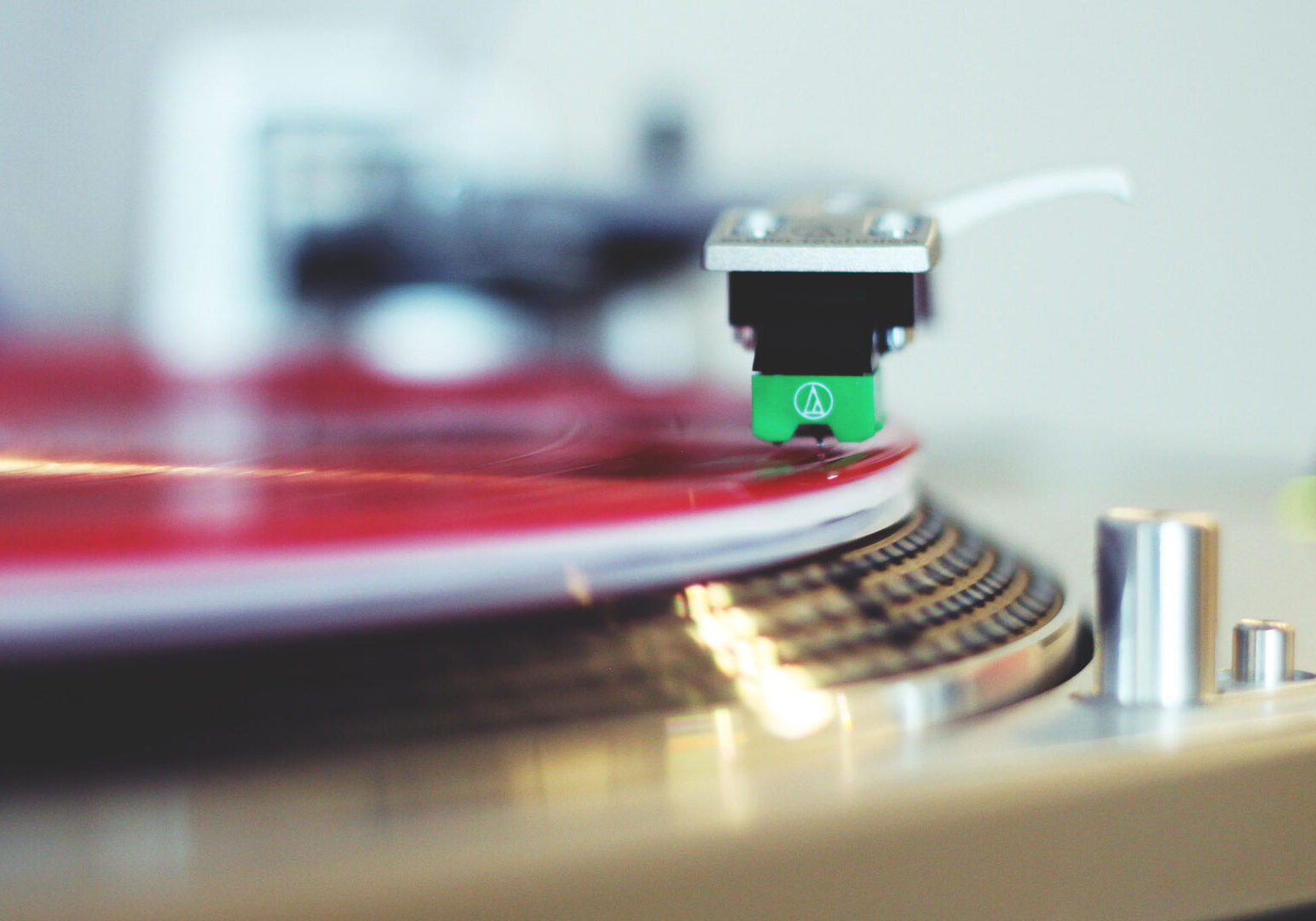 A red vinyl album spins on a turntable.