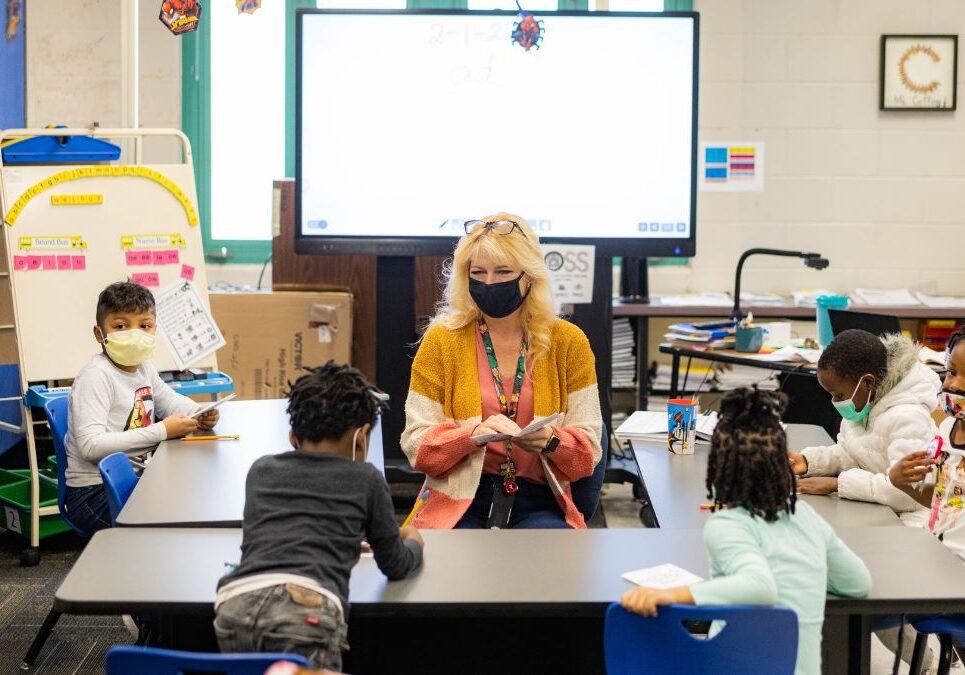 An interventionist works on reading skills with a small group of students Feb. 1 at Faxon Elementary School in Kansas City. Kansas City Public Schools has used federal COVID relief dollars to hire more staff in an effort to give students focused attention and help them catch up from pandemic-related learning loss.