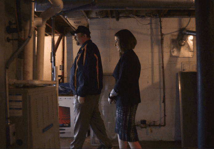 A man and woman walking in a basement