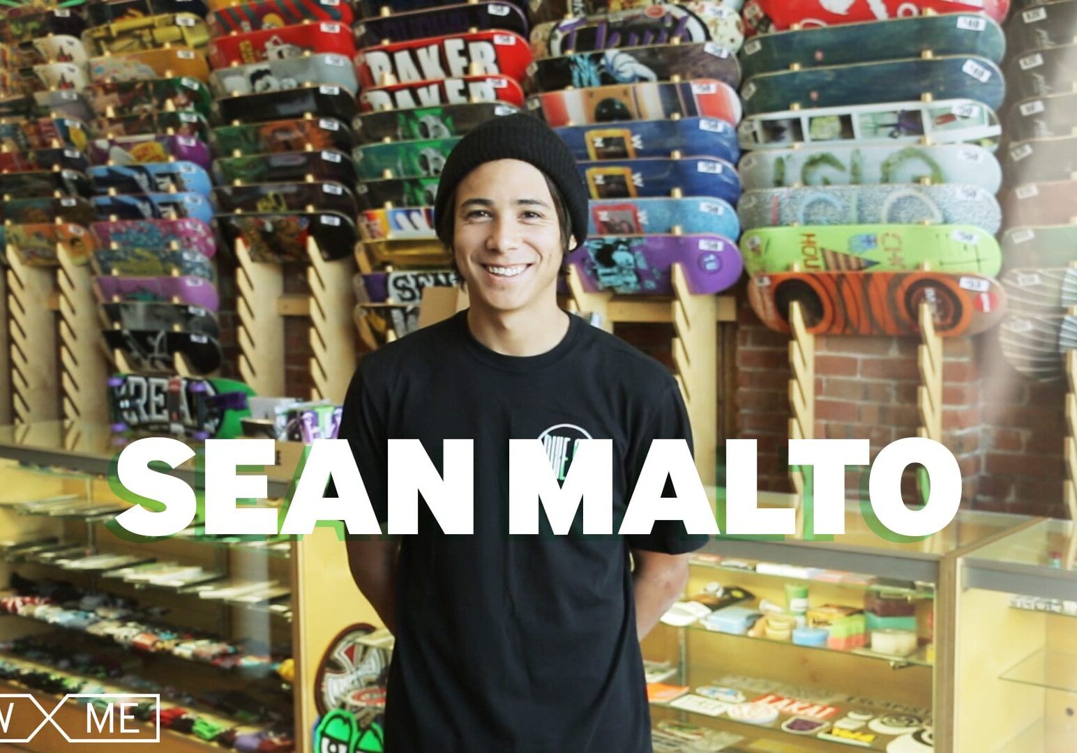 A man stands near skareboards.