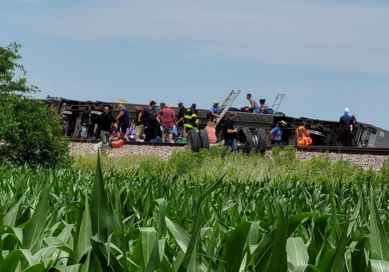 People outside of a crashed Amtrak train car.