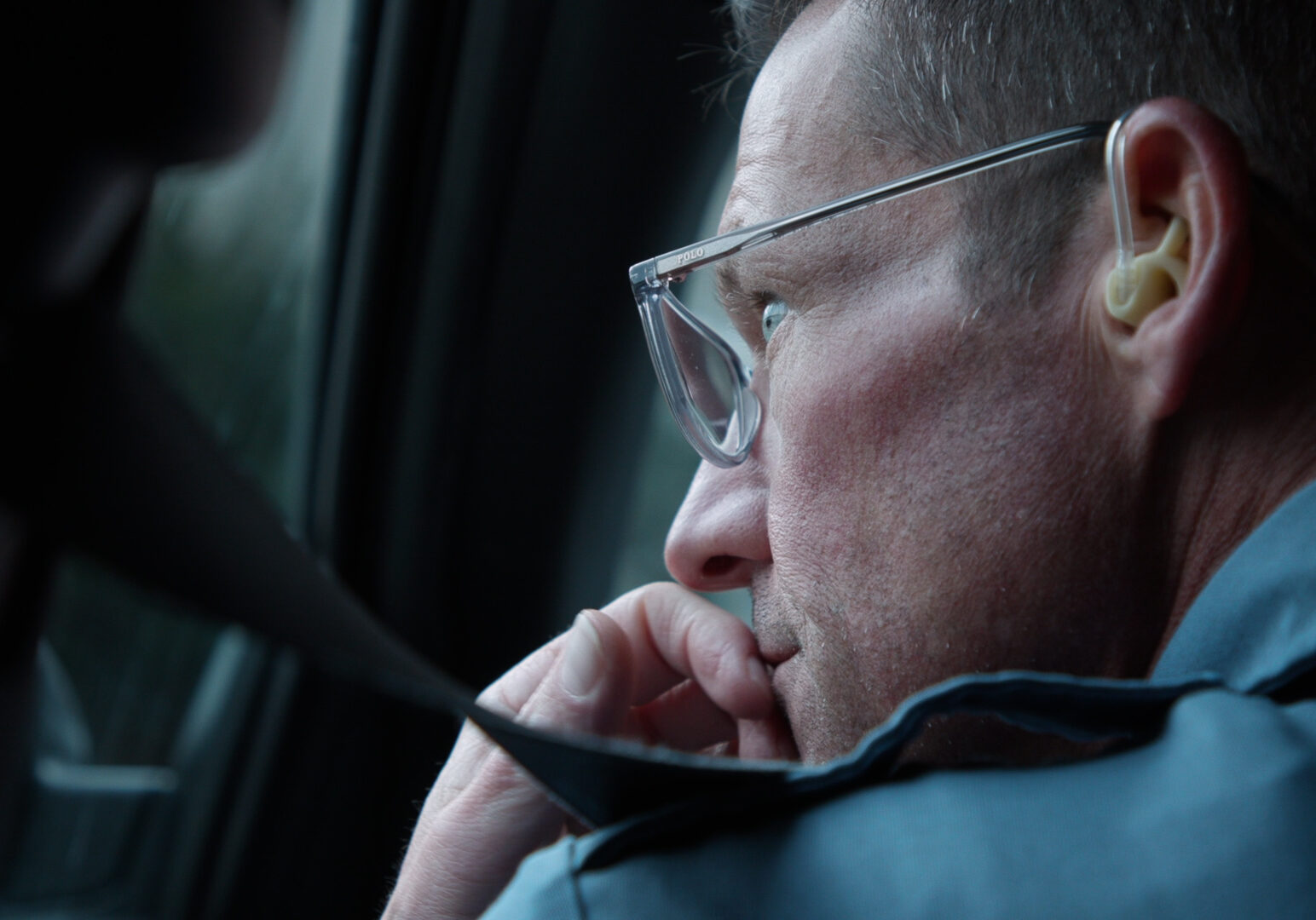 A Kansas City police officer peers out of the window of his car while on patrol.