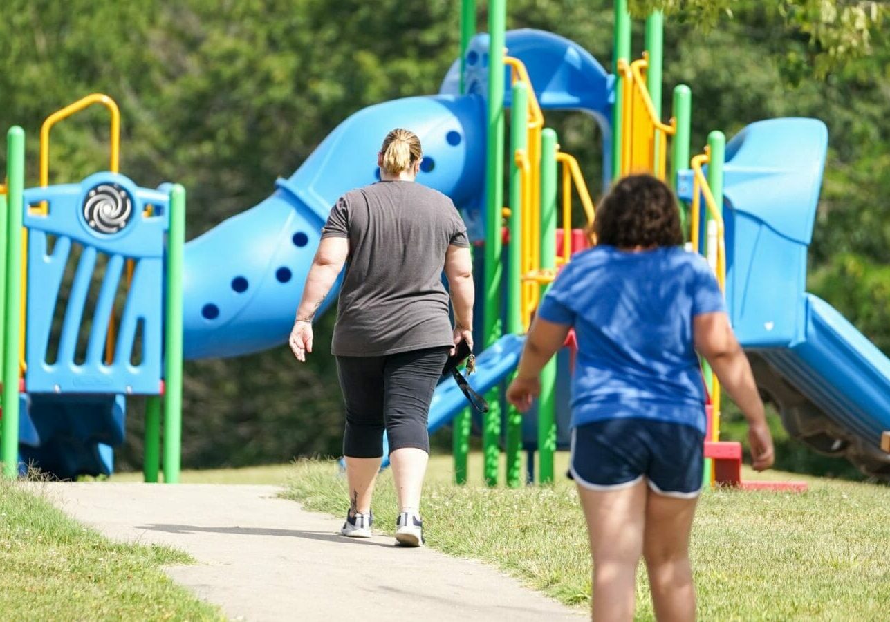 Becky Divine and her daughter, Evie, walk to a playground. Divine has more than $41,000 in student loans.