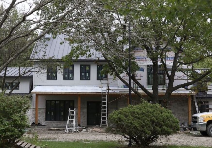 A TrueSon Exteriors truck and ladders sit outside a house renovation in Ashland.