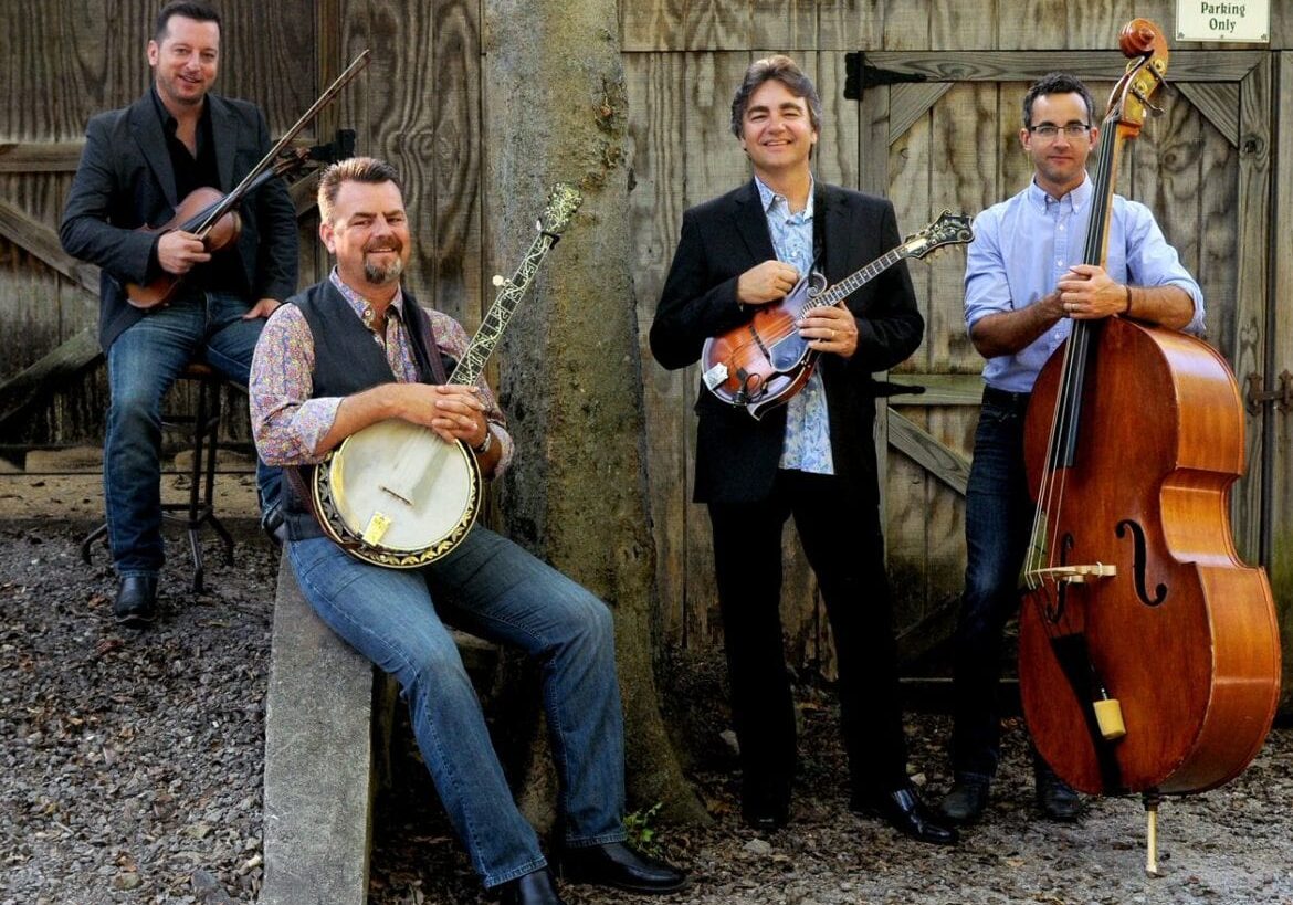 A bluegrass band posing with their instruments.