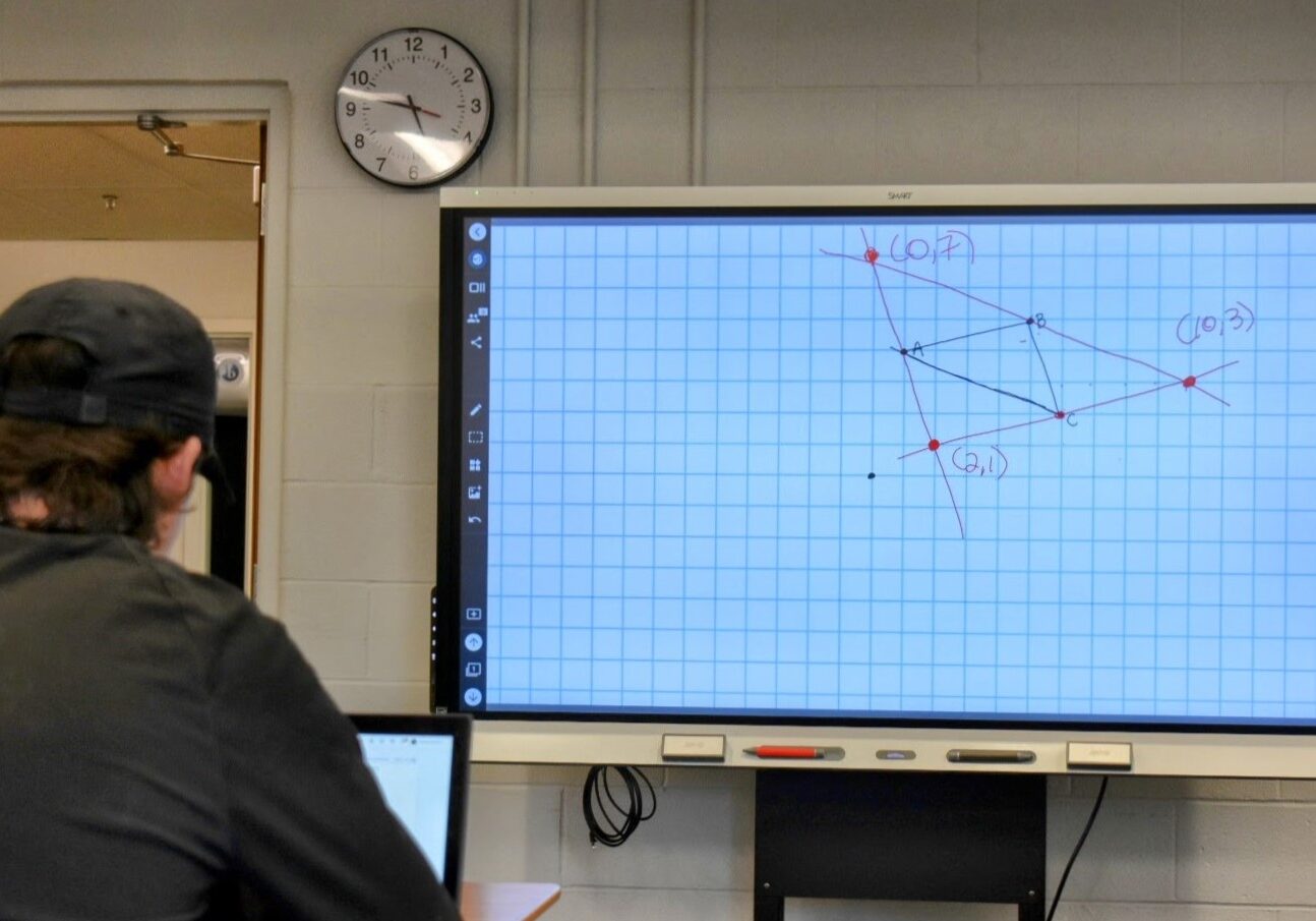 A student works on a math problem with the help of a laptop and smart board in Vetta Manning's summer school class at Lee's Summit High School on June 11.