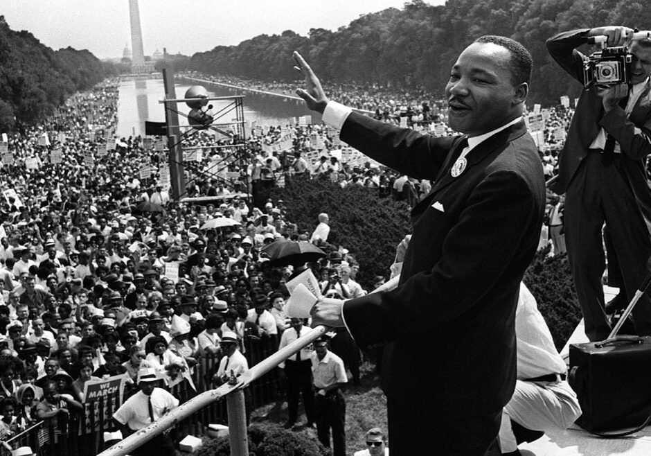 The civil rights leader Martin Luther King waving to supporters