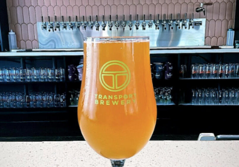 A glass of Transport Brewery beer on a bar.