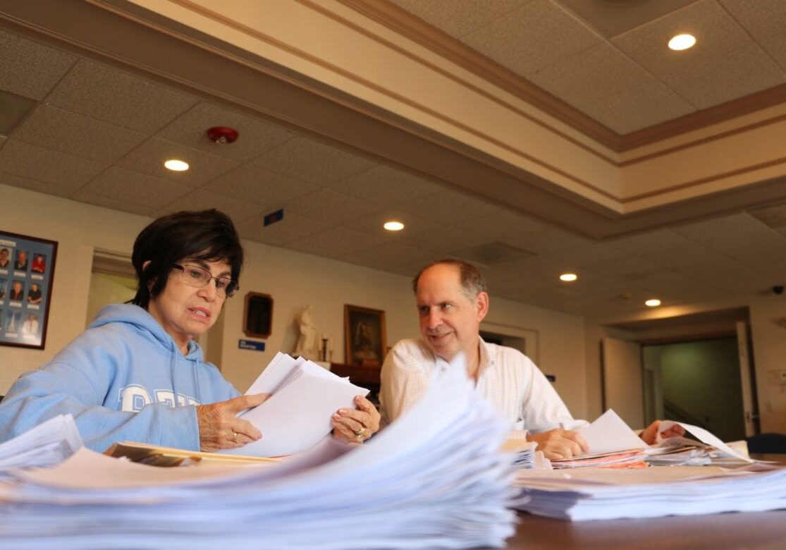 A man and woman read essays.