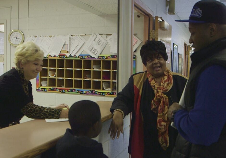 Principal Kirksey and office staff greet a new student and his father at Hartman Elementary.