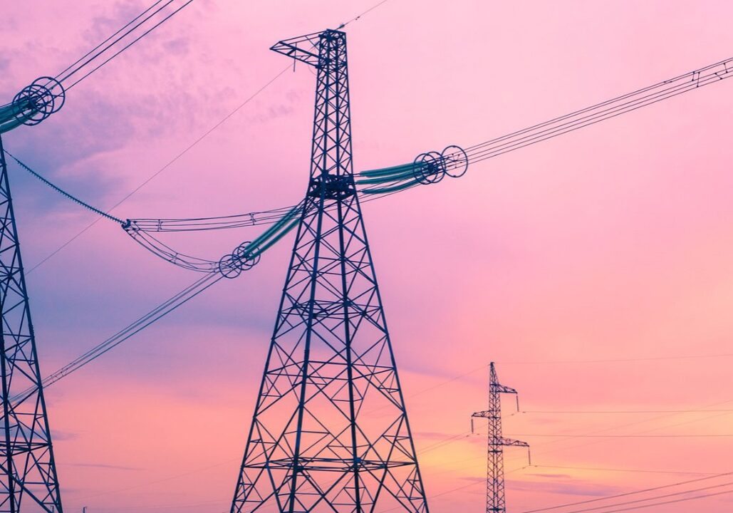 A view of power lines against a pink sunset illustrates a story about how the climate changes affect utility costs and burdens. Flatland reporters Vicky Diaz-Camacho and Catherine Hoffman will report on this issue for the next Flatland Show episode, entitled "The Cost of Utilities in Kansas City."