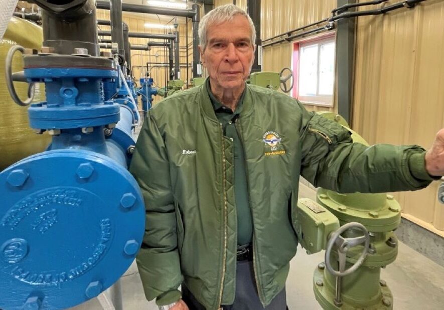 Former Haviland mayor Robert Ellis stands between pipes inside the small town's multimillion-dollar water treatment plant.