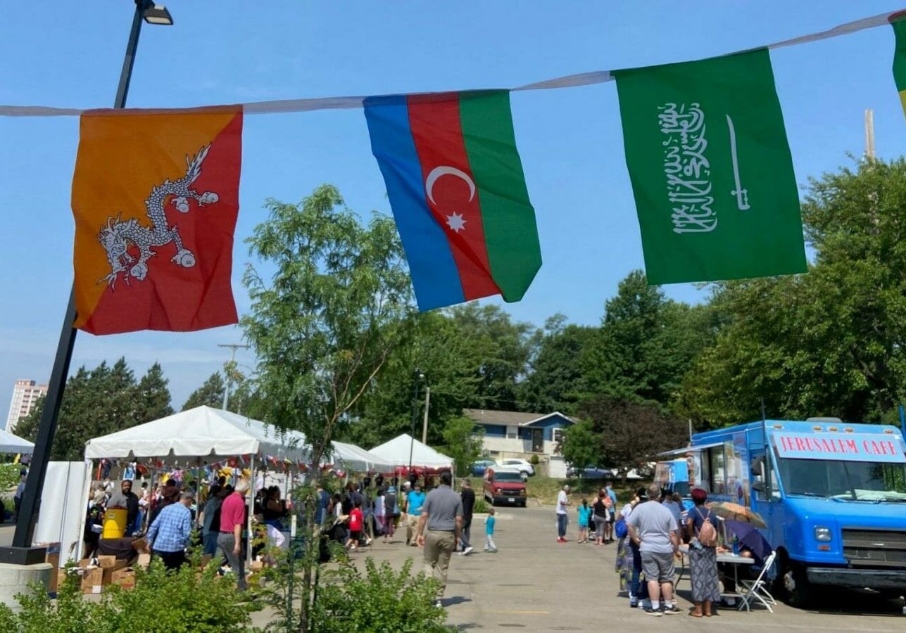 People, businesses and service organizations gather in a parking lot for Kansas City's World Refugee Day event.