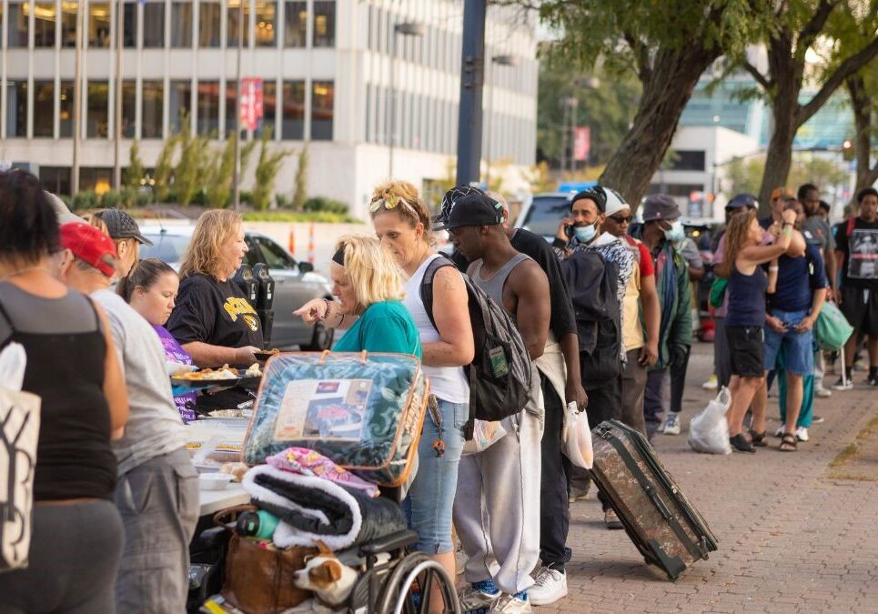 Members of Kansas City Heroes, a local nonprofit, serving a free meal to unhoused individuals on Oct. 4. The organization hosts this dinner every Tuesday in Washington Square Park.