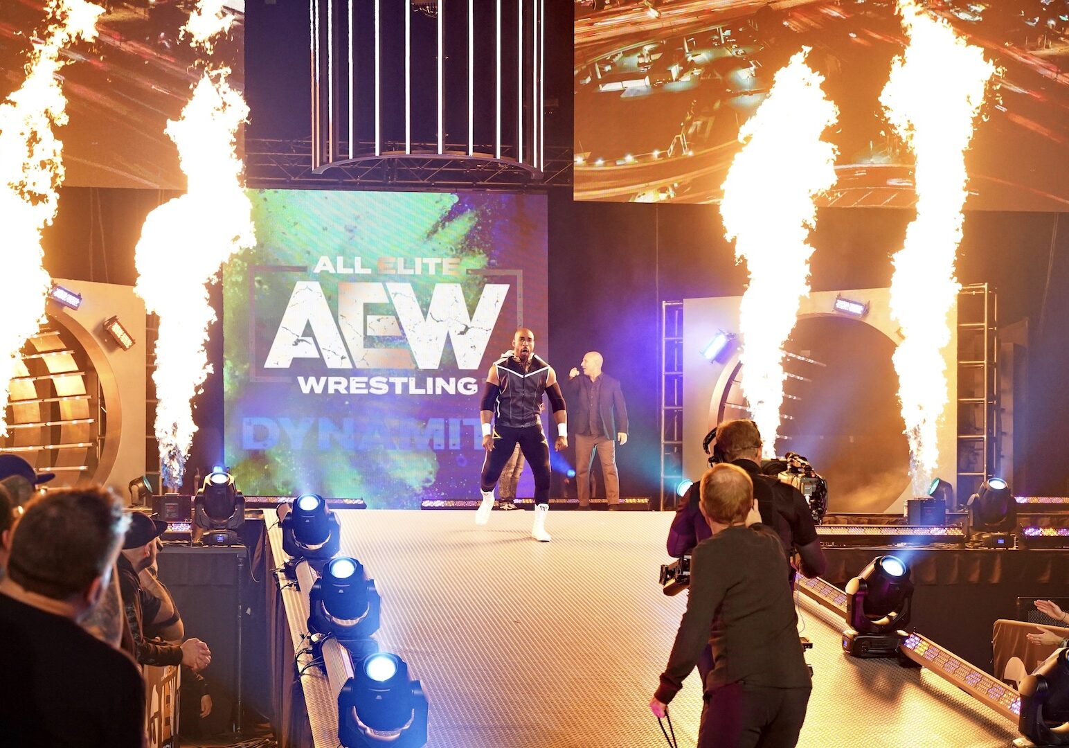 A wrestler enters the arena to flame throwers.