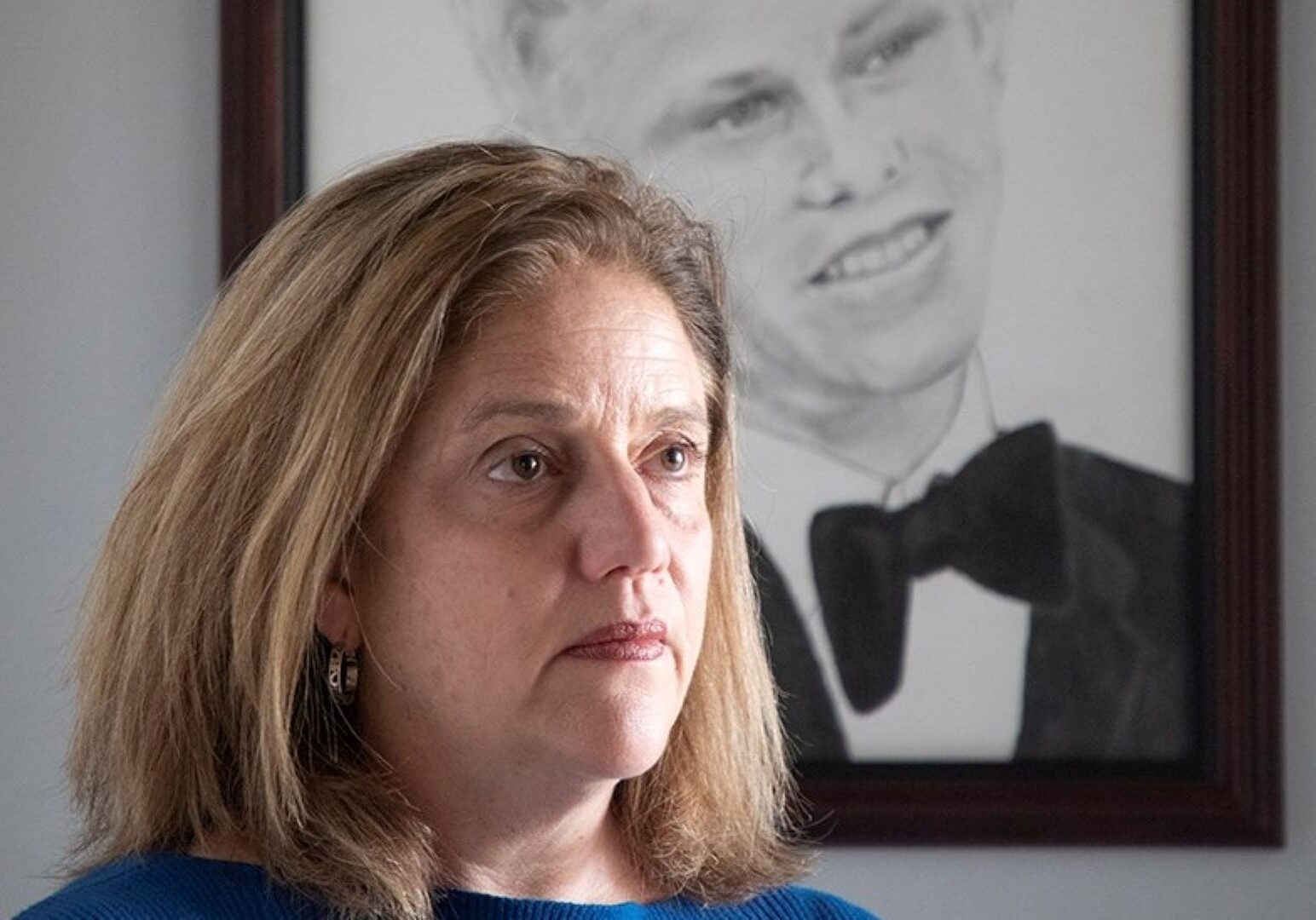 Sheila Albers in front of a portrait of her son, John, who was shot and killed by an Overland Park police officer.