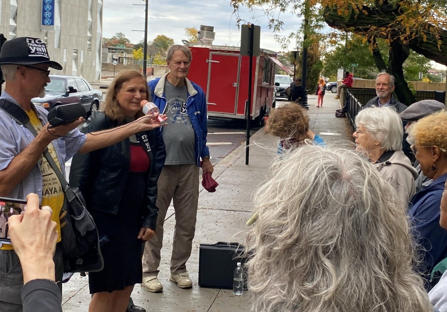 A group of anti-nuke activists gather on the sidewalk.