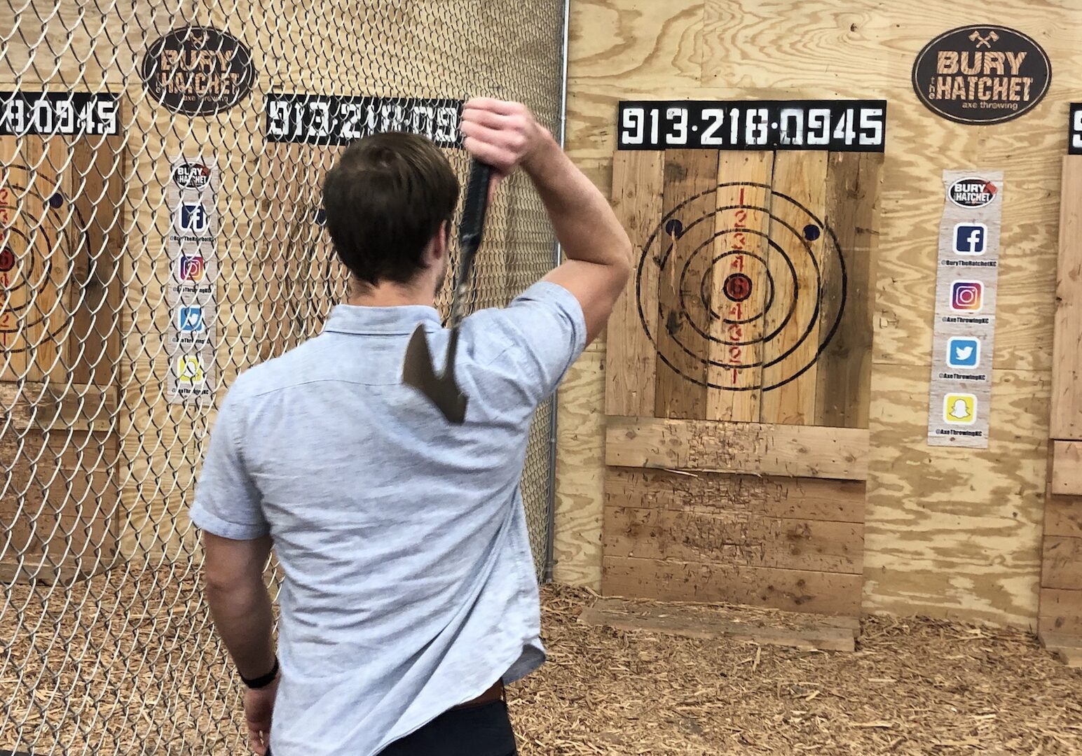 An axe thrower steps up and aims at a target.