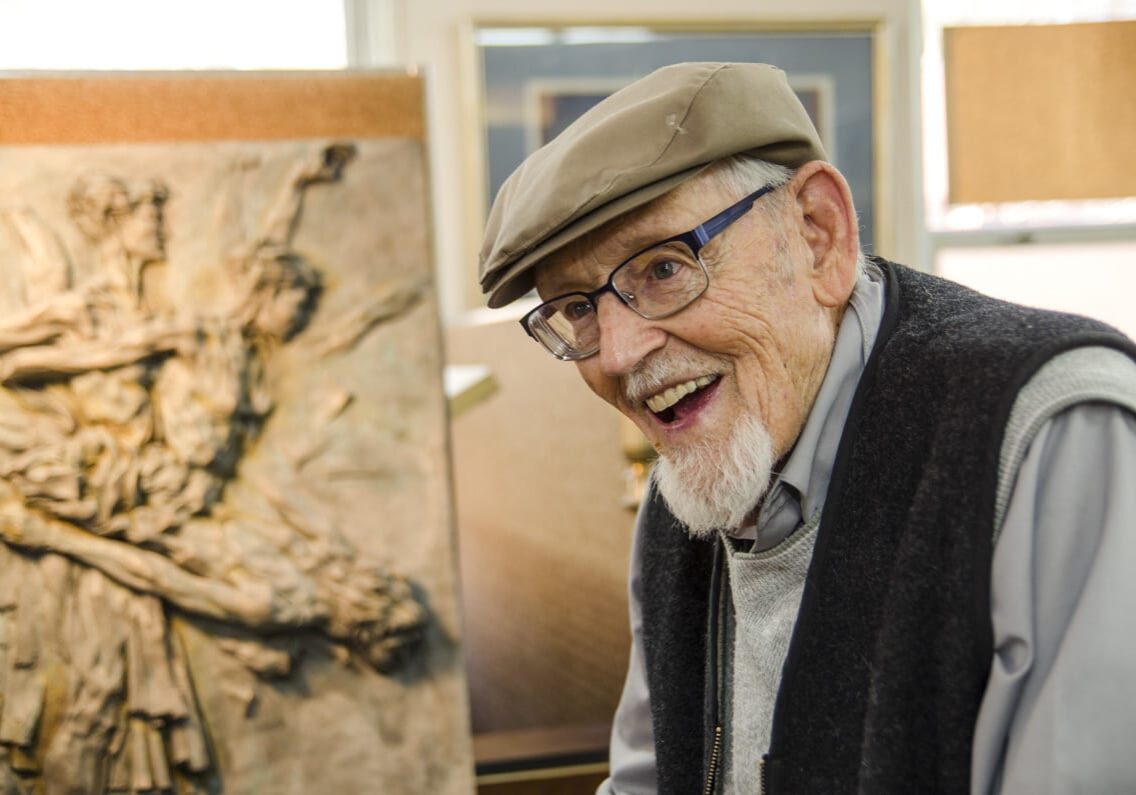 A man speaking near his painting.