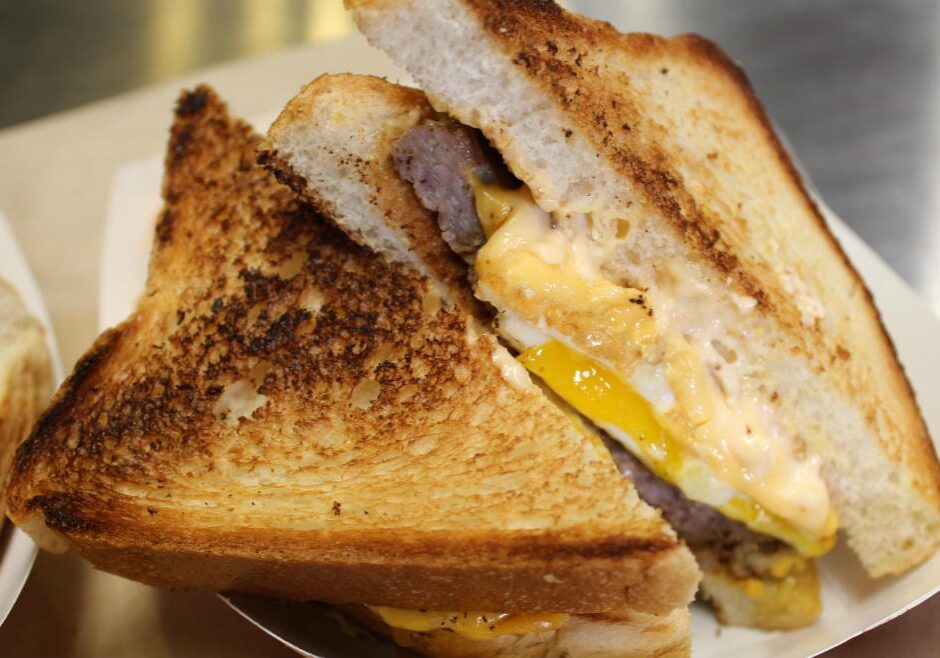 Photo of toasted sandwich with egg, cheese and sausage.
