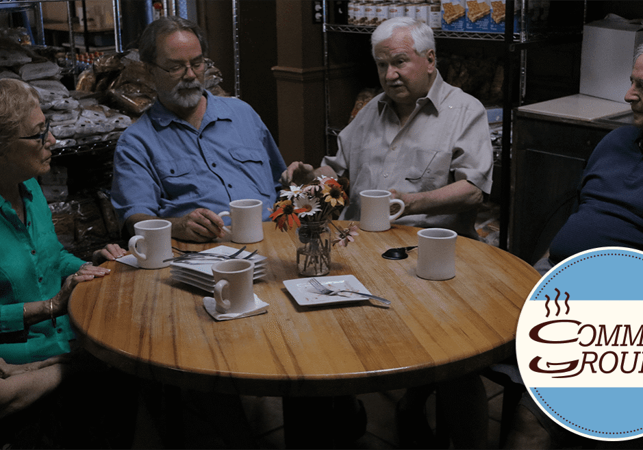 A group of five people seated over coffee at a restaurant