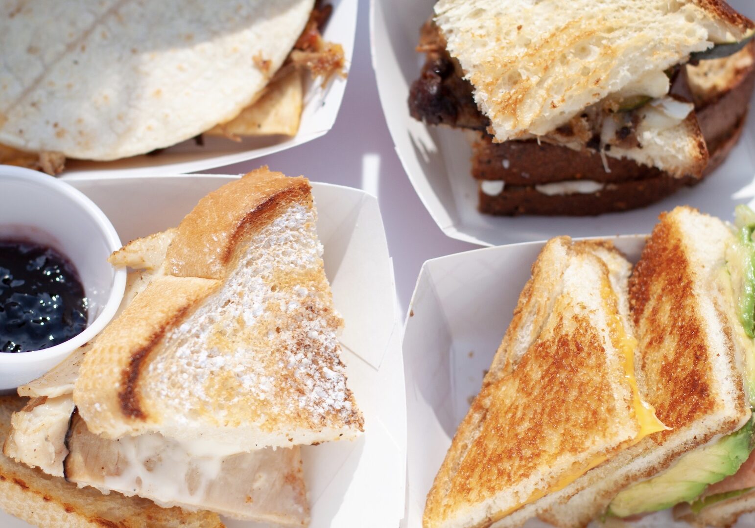 Four grilled cheese sandwiches on a tray