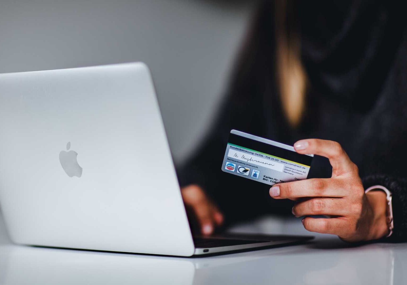 A person entering credit card information via a laptop computer.