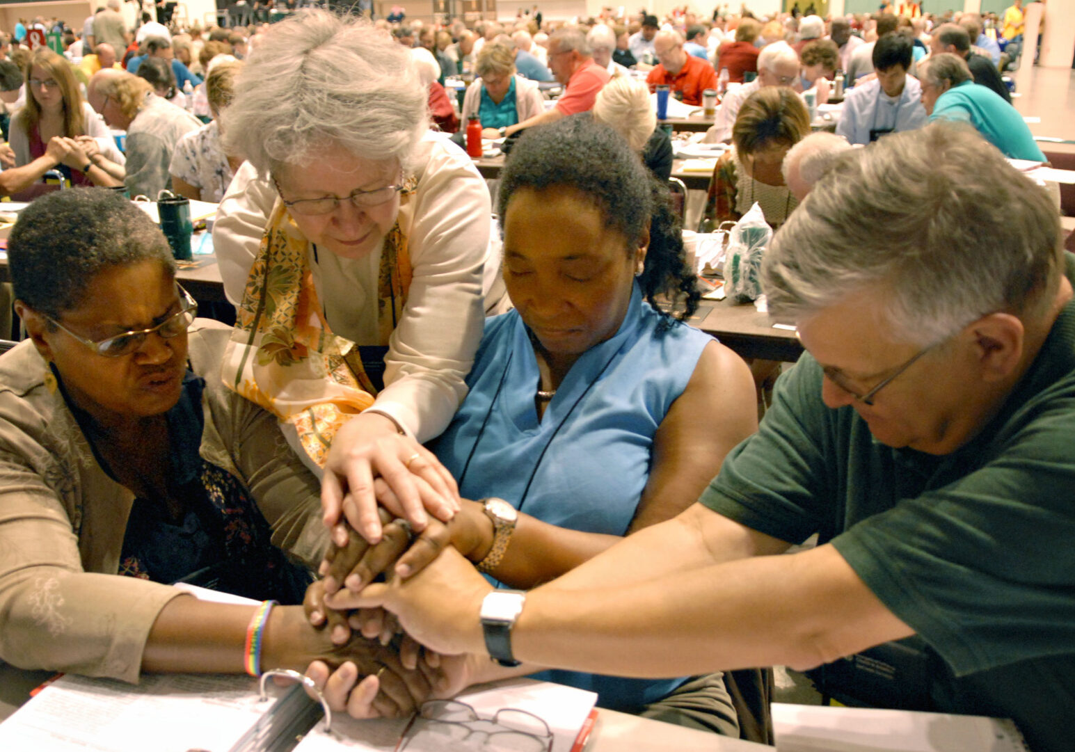 Evangelical Lutheran Church of America voting members, left to right, Orinda Hawkins-Brinkley, Diane Yeager. Marj Ellis and Steven Schnittke, along with other members of the ELCA, stop for a moment of prayer Friday morning Aug. 21, 2009 during their assembly at the Minneapolis Convention Center in Minneapolis. More than 1,000 members debated and voted on whether to allow gay and lesbian clergy to serve while be in committed same-sex relationships. (AP Photo/Dawn VIllella)
