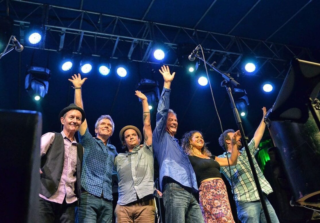 A band waving goodbye on stage.