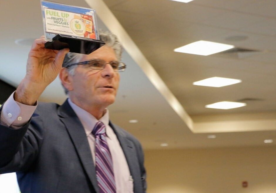 Oran Hesterman, CEO of the Fair Food Network in Ann Arbor, Mich., held up a miniature replica of a billboard his organization had throughout Detroit advertising its Double Up Food Bucks program for food stamp recipients. Hesterman was in Kansas City, Kan., on Thursday for a food summit.