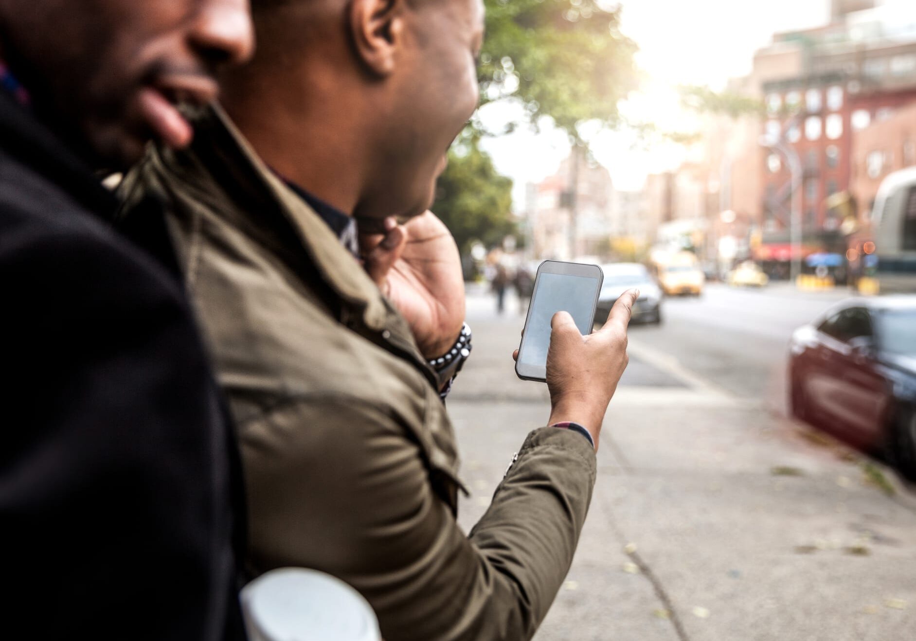 A man using a smartphone to hail a cab