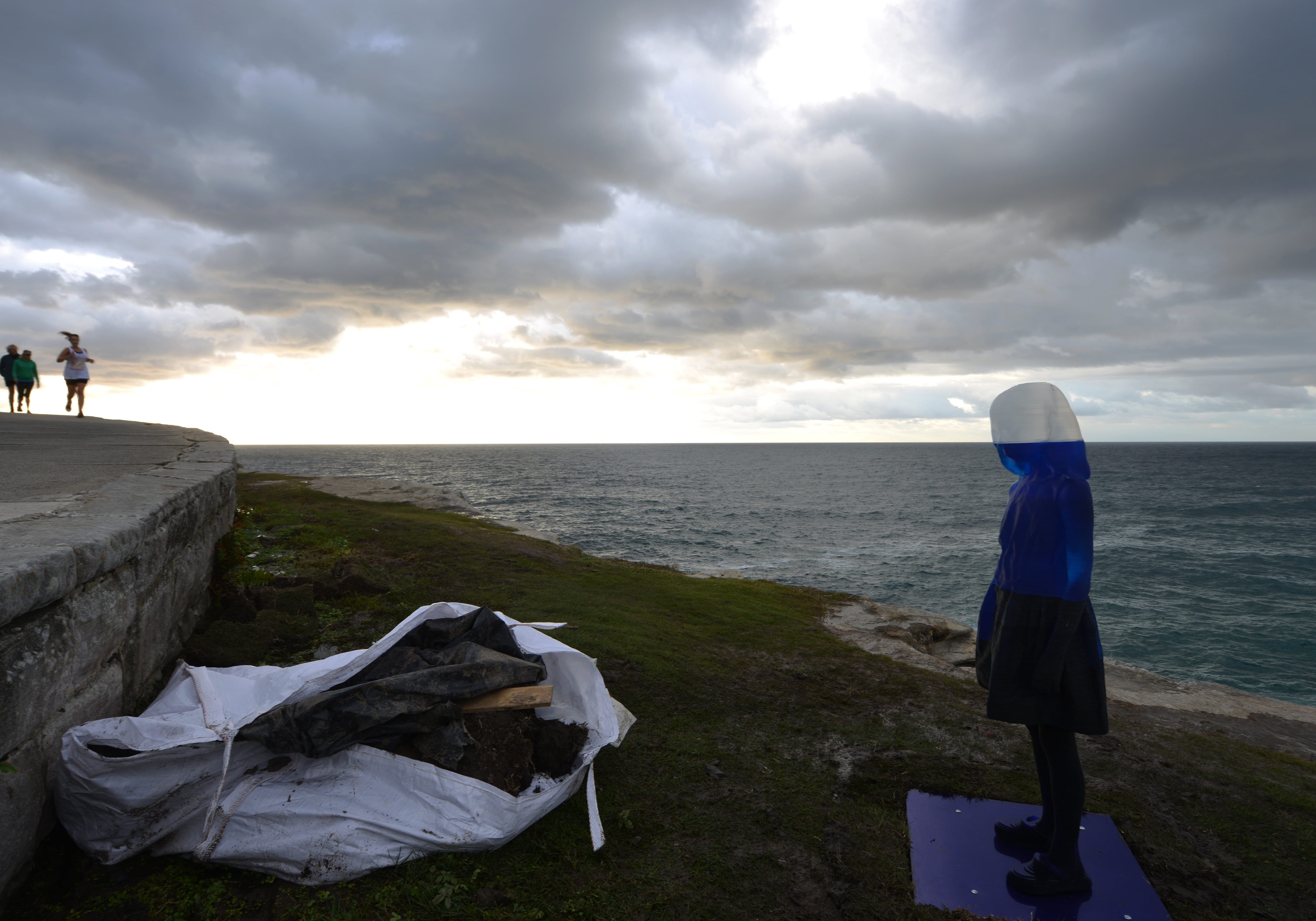 A runner passes a ghostly sculpture on display between Bondi Beach and Tamarama Beach in Sydney.
