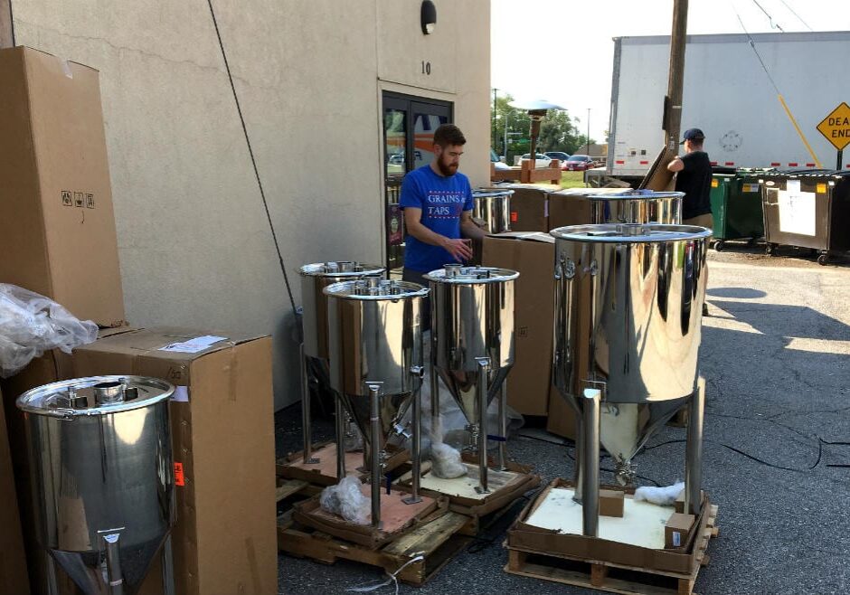 Brian Bixby and Brian Freymuller (back) unpack the fermenters