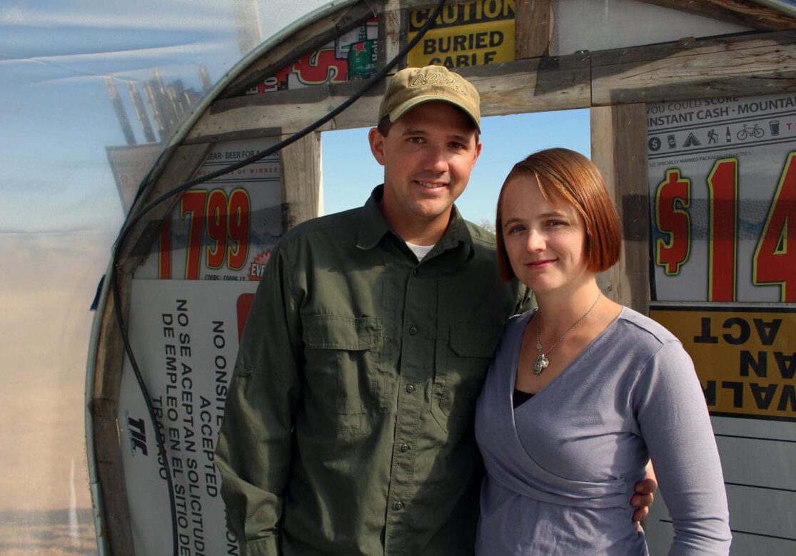 A man and woman standing on their farm.