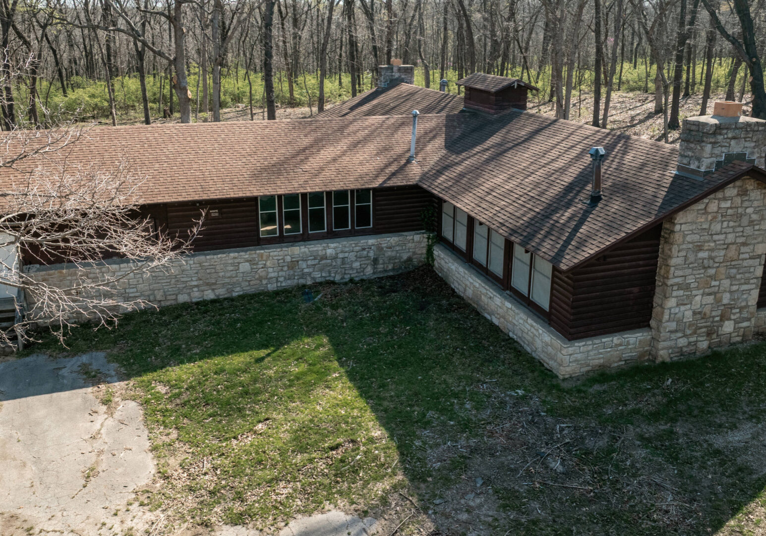 Spring growth surrounds Hope Lodge in Swope Park on April 08, 2025, in Kansas City, Missouri. Hope Lodge is the last functional building remaining from Camp Hope, a dilapidated summer camp within Swope Park. (Chase Castor | Flatland)