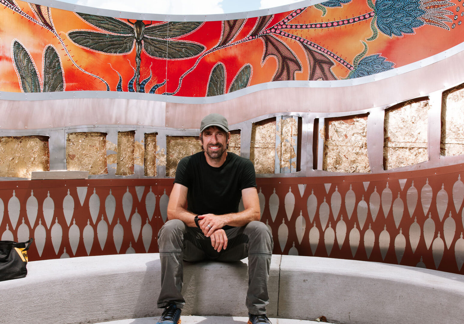 Michigan-based artist Aaron Squadroni sits inside Fire Keepers Circle, the art installation he and Leah Yellowbird created at Heritage Park in Olathe, Kansas. Squadroni was putting the finishing touches on the sculpture in advance of the ribbon cutting scheduled for Saturday. (Chase Castor | Flatland)