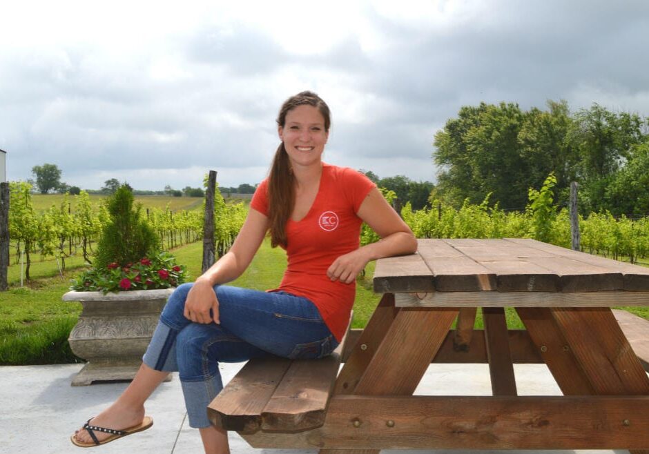 Taylor Berggren poses in front of KC Wine Co.'s Vineyard