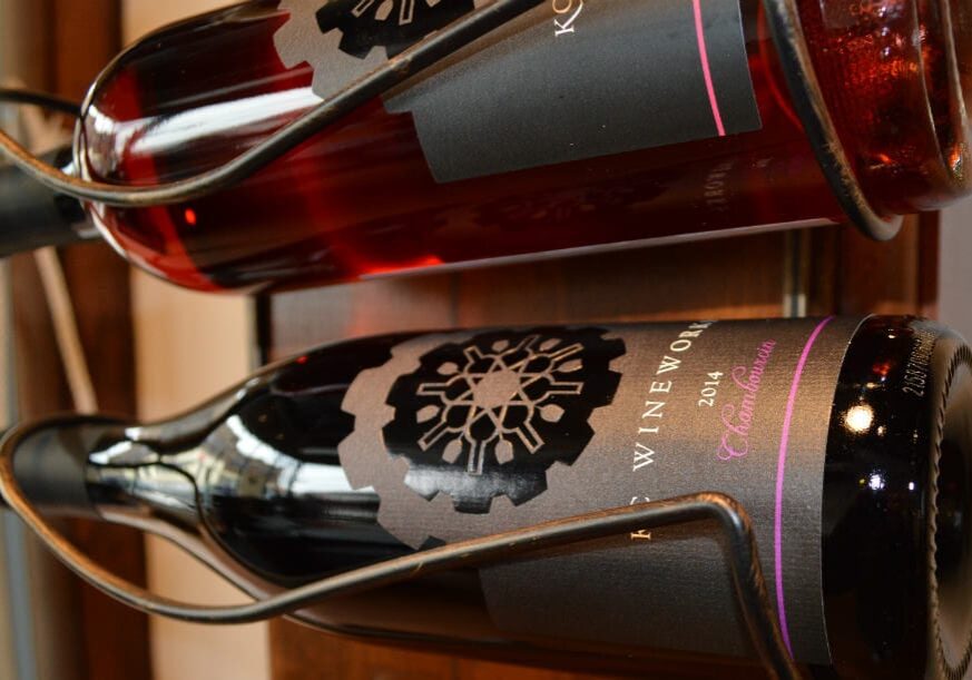 A pair of bottles hang on a wall.