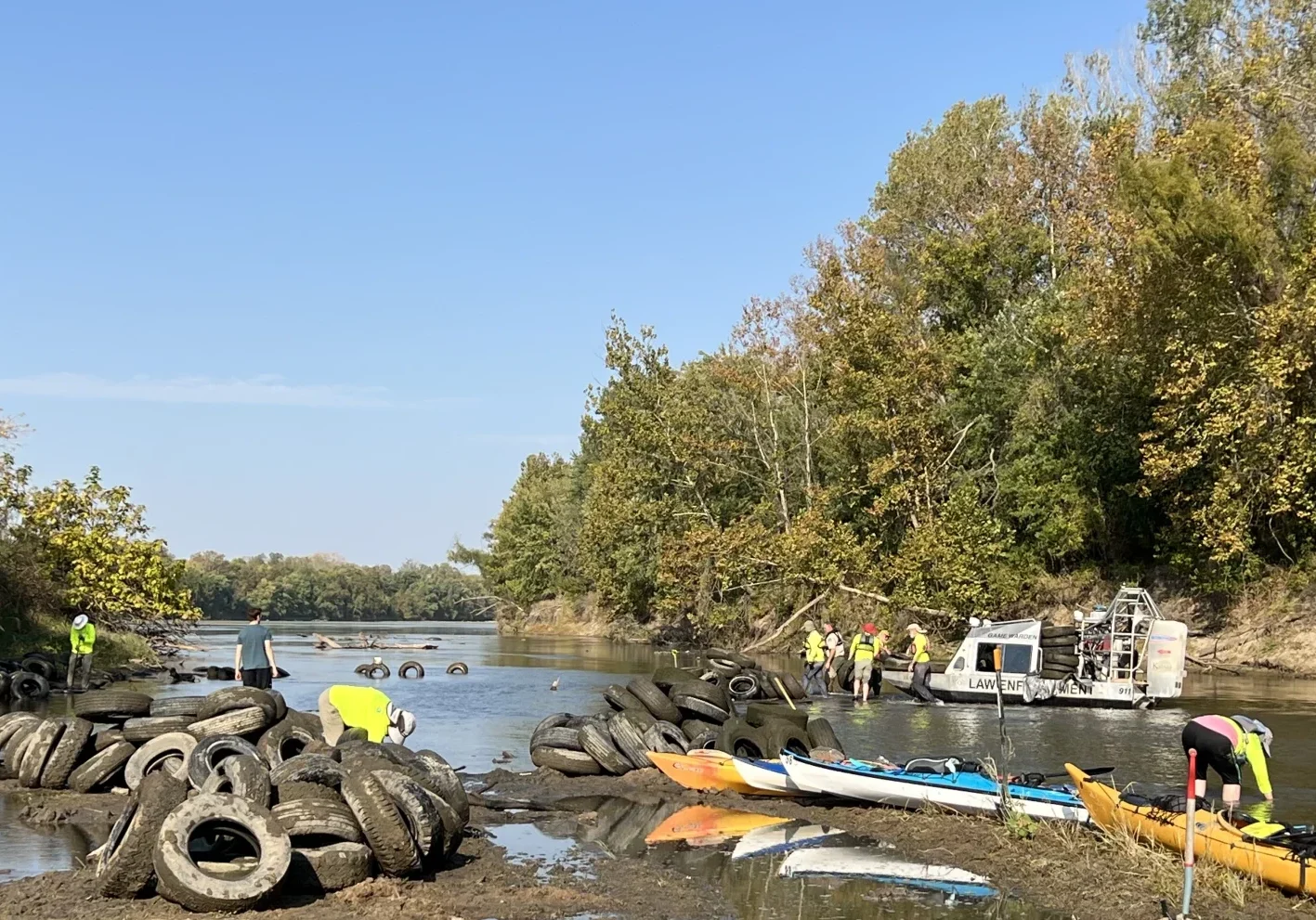 Friends of the Kaw’s trained volunteers pull tires out of the Kansas River between Eudora and De Soto in October. A Kansas Department of Wildlife and Parks game warden helps ferry the tires away by boat.